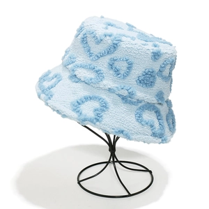 Detail of light blue faux shearling bucket hat with dark blue plush heart patterns