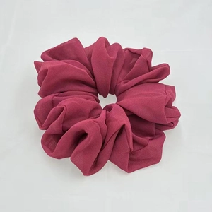 Detailed close-up of dark rose red chiffon hair scrunchie with soft ruffled texture