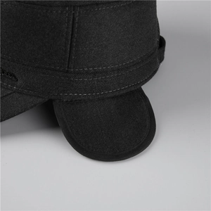 Détail de la casquette d'hiver avec cache-oreilles montrant le tissu épais et couture