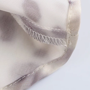 Close-up of tie-dye satin skirt featuring high-quality hem stitching and fabric texture