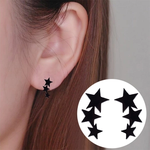 Detail view of black triple star stud earrings on model and white background