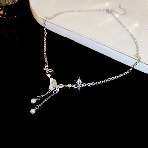 Detail showing butterfly pendant with mother-of-pearl, zircon crystals and pearl tassels