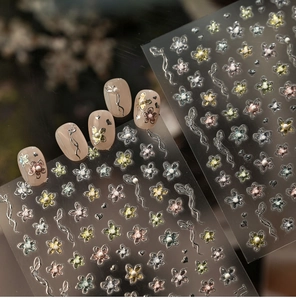 Detailed view of floral nail stickers with pearl accents and iridescent metallic finish