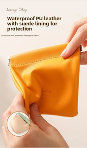Detail showing the waterproof PU leather texture and squeeze closure of the orange pouch