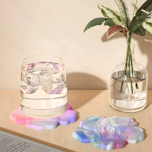 Floral silicone coasters in purple gradient and marble texture on wooden desk