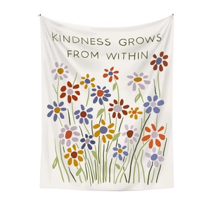 Detail of floral tapestry featuring kindness grows from within motto on white background