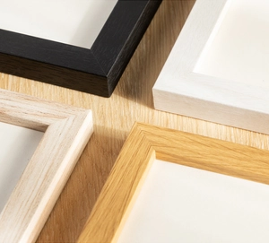 Detailed corner view of four minimalist wooden frames in black, white, and natural wood textures