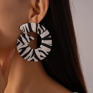 Gros plan d'une boucle d'oreille en tissu à motif zèbre portée par un mannequin en macro