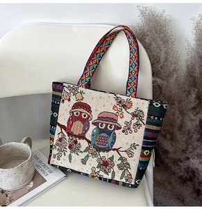 Detail of canvas tote bag featuring ethnic owl embroidery and geometric woven straps