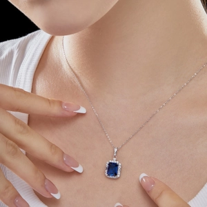 Detail of s925 silver necklace featuring a rectangular blue sapphire and white zircon