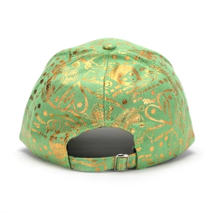 Détail de la casquette verte avec imprimés dorés et boucle métallique réglable au dos