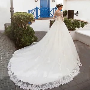 Luxurious white ball gown wedding dress with long lace sleeves and a long trailing hem