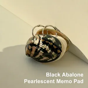 Macro shot of black abalone pearlescent notepad with metallic loose-leaf ring