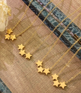 Détail de colliers étoile plaqués or 18 carats sur un fond texturé de style vintage