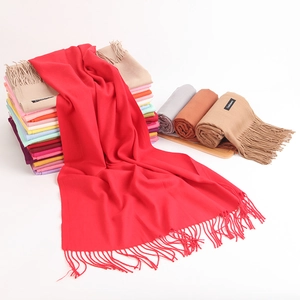 Detail shot of assorted colorful cashmere plaid scarves featuring decorative tassels