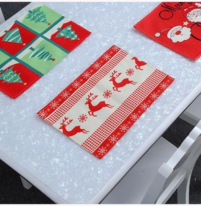 Close-up of Christmas placemats featuring Santa, reindeer, and tree prints on linen fabric