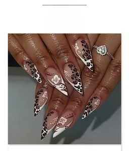 Détail de faux ongles amande avec motif léopard et art floral français blanc