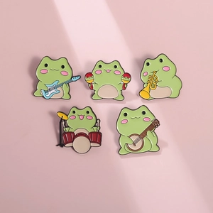Set of five cute cartoon green frog enamel pins playing musical instruments on a soft background