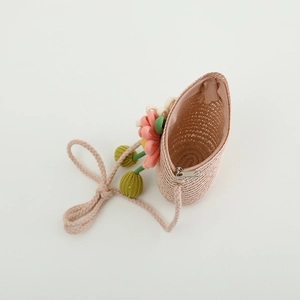 Close-up of kids straw crossbody bag with handmade colorful floral decor and zipper detail
