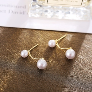 Detail of French vintage pearl earrings with gold accents on premium leather texture