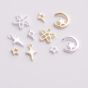 Detail of assorted gold and silver mini star, moon and cross charms for DIY nail art and jewelry
