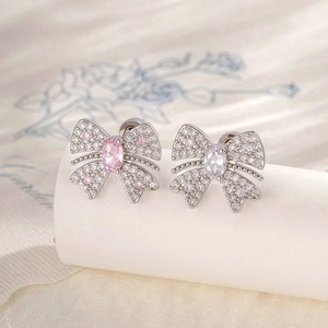 Silver butterfly earrings with pink and clear zircons displayed on a silk scroll