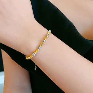 Macro shot of 18k gold plated and silver textured beads on a stylish bracelet for women