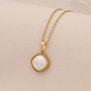 Close-up of golden stainless steel necklace with a square-edged pearl pendant