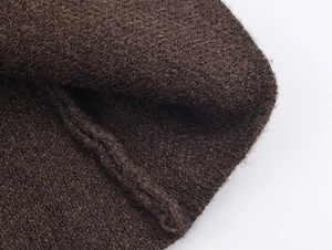 Dettaglio macro del tessuto a maglia marrone scuro con texture fine e cuciture di qualità