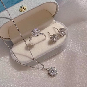 Elegant rotating flower jewelry set with necklace earrings and ring on blue velvet