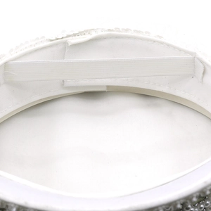 Detailed interior of a white sequined party hat with inner sweatband and elastic strap