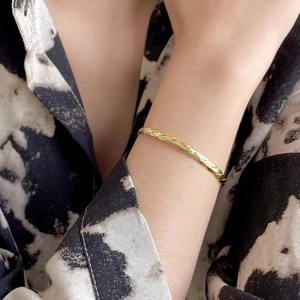 Minimalist S925 sterling silver twisted rope bangle in gold finish worn on wrist