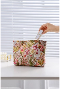 Placing lipstick into a floral jacquard cosmetic bag with vintage woven flower patterns