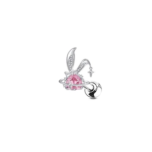 Macro detail of silver bunny piercing jewelry with pink heart gem and planetary ring