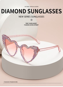 Close-up of pink heart-shaped sunglasses with sparkling diamond rhinestone accents