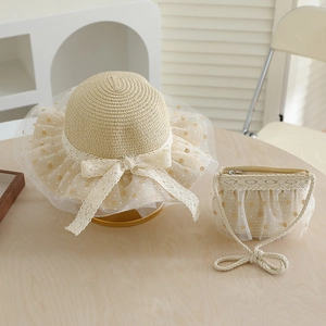 Close-up of girls' straw sun hat and matching bag with lace bow and gold dot tulle detail