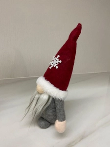 Detailed view of Christmas gnome plush with red snowflake hat and long white beard decor