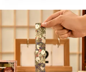 Macro view of vintage floral washi tape with white chrysanthemums and green leaf patterns