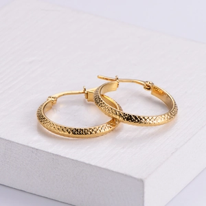 Boucles d'oreilles créoles dorées avec texture losange en métal poli brillant