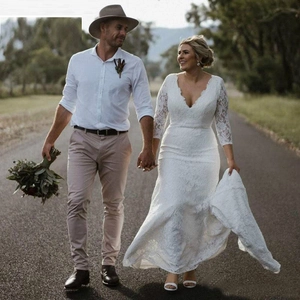 Elegant white lace mermaid wedding dress with deep V-neck and 3/4 sleeves in outdoor scene