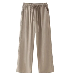 Detail of light khaki wide-leg pants with drawstring elastic waist and side pockets