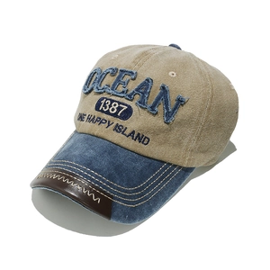 Detail of OCEAN embroidery and leather brim with white zigzag stitching on baseball cap