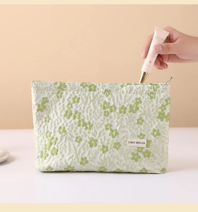 Close-up of floral jacquard makeup bag with metal zipper and linen texture finish
