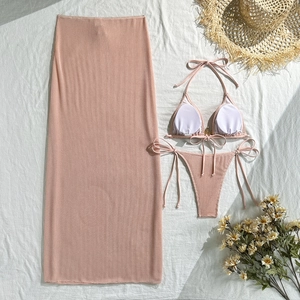 Detailed macro view of pink waffle textured three-piece bikini set and long mesh skirt
