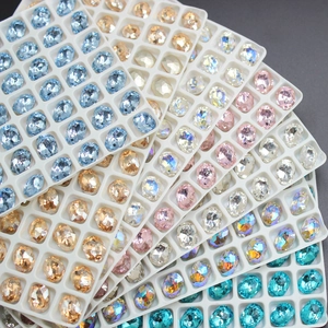 Detailed view of oval 3D pointed rhinestones in colorful shades on white trays