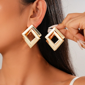 Minimalist geometric square earrings in gold metal finish worn by a model
