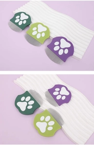 Close-up of pet grooming combs with fine stainless steel teeth and paw print handles