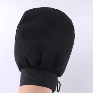 Close-up of black exfoliating glove showing matte texture and elastic wrist cuff