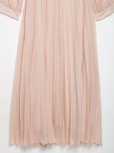 Detail of pink pleated chiffon dress showing vertical pleats on sleeves and hemline