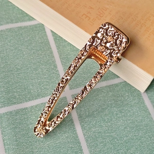 Elegant gold hollow triangle hair clip with embossed metal texture and geometric pattern